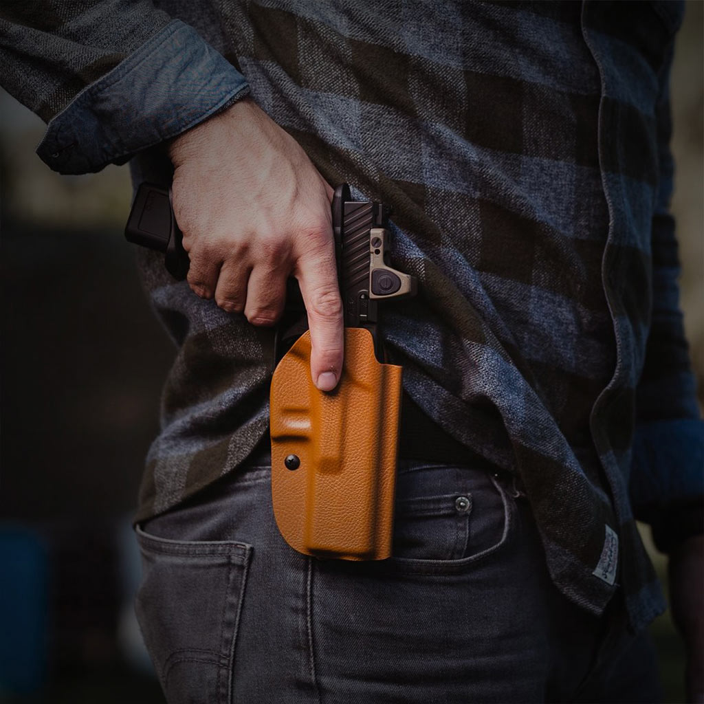 A man draws his firearm from a custom colored Prodraw holster.