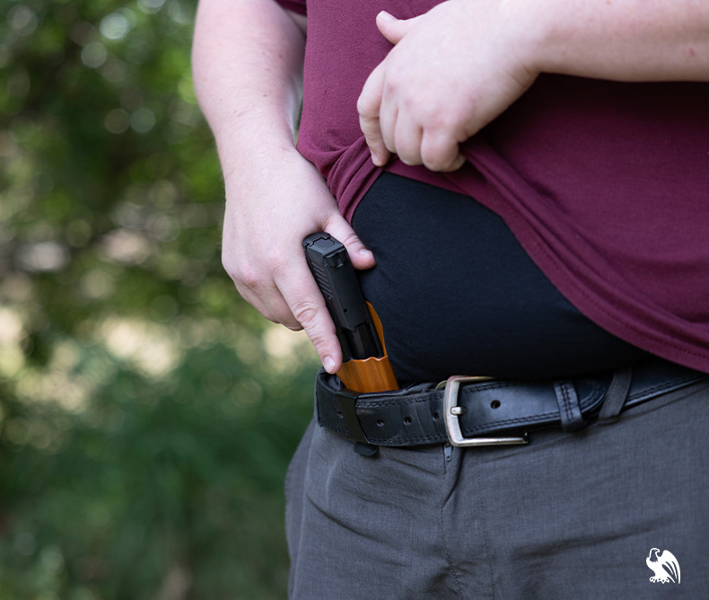 Man drawing his handgun from his holster from Vedder Holsters.