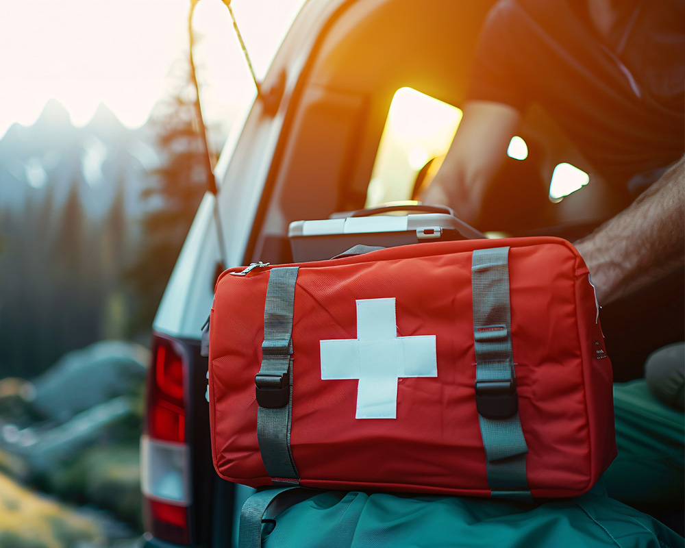 Medical Bag sitting on the back of a car with a person using one of the medical tools that were stored inside it. 