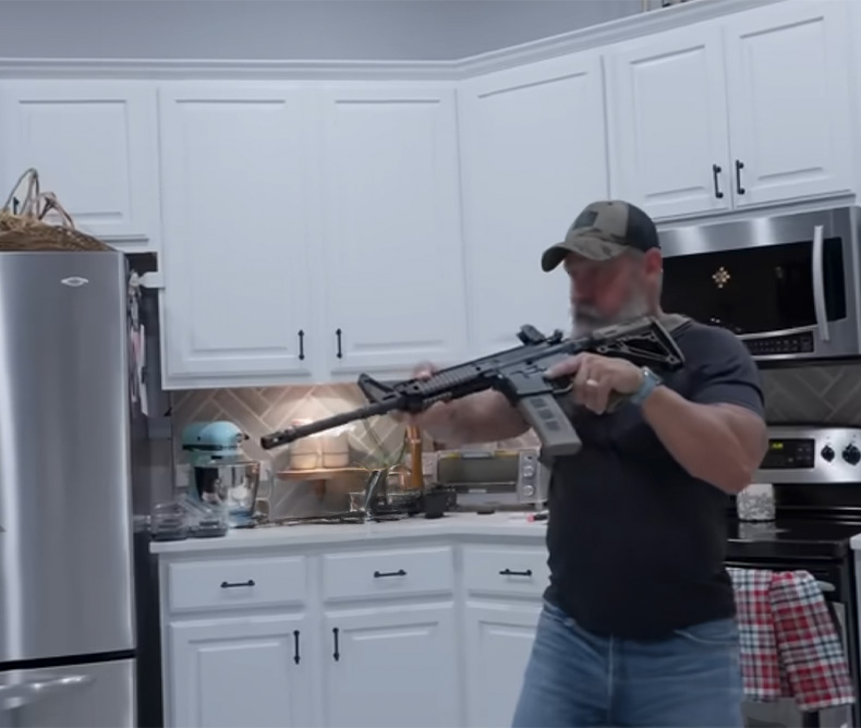 Home Defense Rifle -  Man holding his home defense assault riffle inside his kitchen