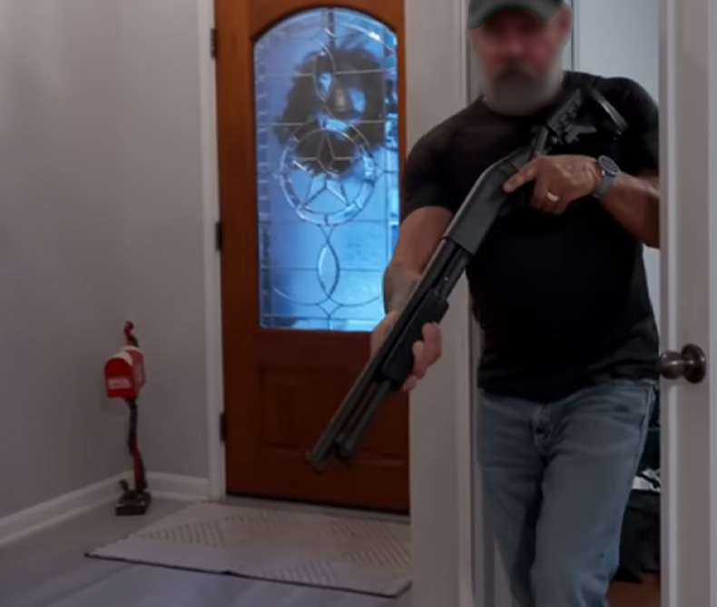 Home Defense Shotgun - Man holding his shotgun inside his home