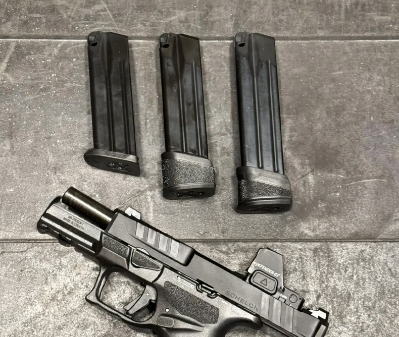 The Springfield Armory Echelon 4.0C and 3 of its magazines next to each other laying on a table.