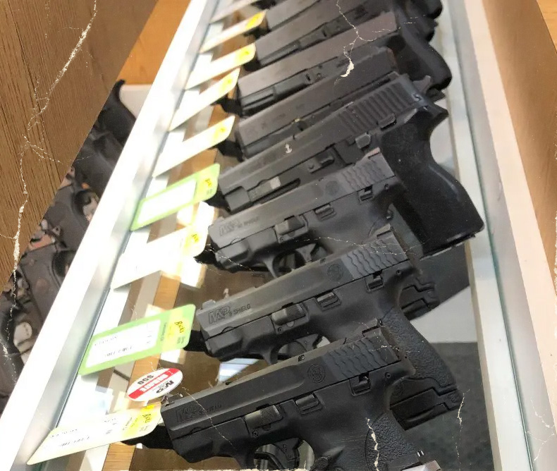 Used guns displayed on a counter available for purchase