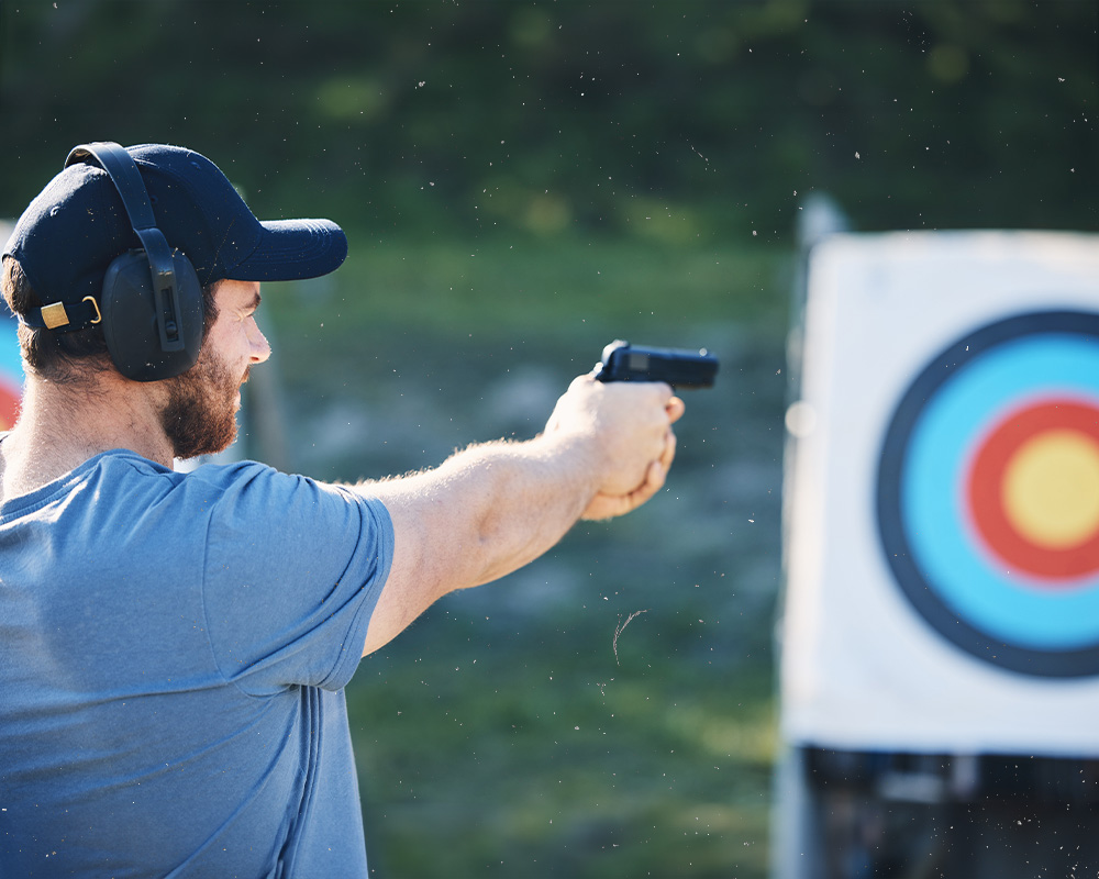 Man at the shooting range with a pistol shooting at targets