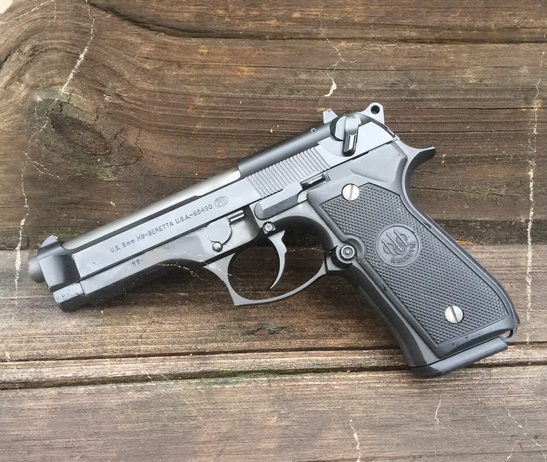 Beretta M9 handgun photography laying on a bench