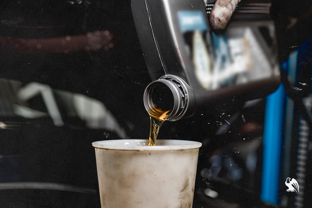 Motor oil being poured into a white cup